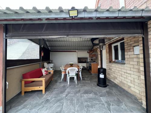 a patio with a table and chairs in a garage at Cherry Holiday House in Khandria