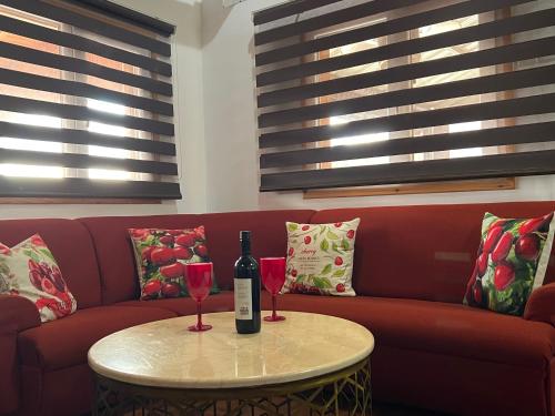 a bottle of wine and two glasses on a table at Cherry Holiday House in Khandria
