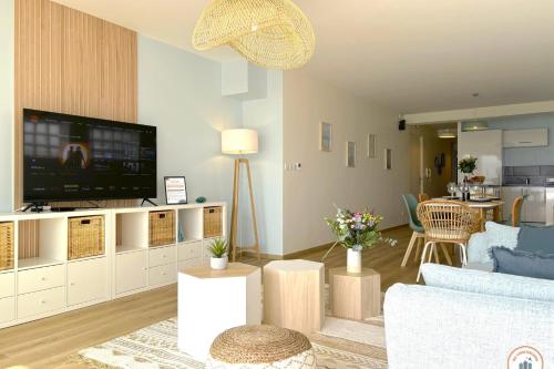 ein Wohnzimmer mit Sofa und Fernseher in der Unterkunft Le Bord de Mer - Vue Mer - Terrasse - Parking in Le Havre