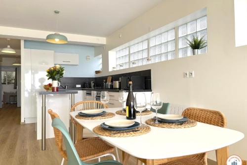 eine Küche und ein Esszimmer mit einem weißen Tisch und Stühlen in der Unterkunft Le Bord de Mer - Vue Mer - Terrasse - Parking in Le Havre