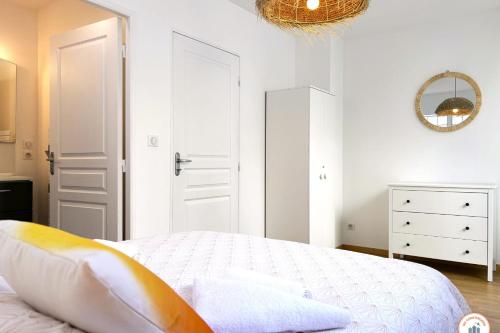 une chambre blanche avec un lit et un miroir dans l'établissement Le French Riviera - Vue Mer - Terrasse - Parking, au Havre