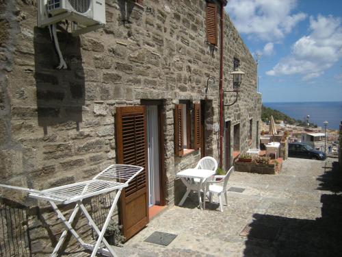 a stone building with chairs and a table on a patio at Residence Timeo in Ustica