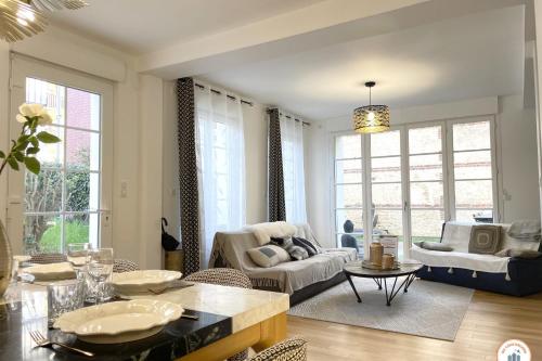 a living room with a table and chairs and a living room at The Garden House - Jardin Parking Hypercentre in Deauville