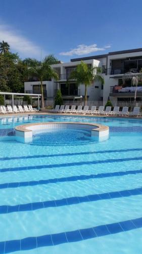 a large swimming pool with chairs and a building at Santa Fe Relax in Santa Fe de Antioquia