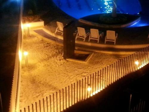 a snow covered patio with chairs and lights at night at Santa Fe Relax in Santa Fe de Antioquia