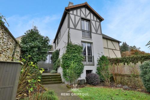 une maison blanche avec un toit noir dans l'établissement La Véranda Enchantée 4 - Garden - Fireplace - City Center - 6P, à Honfleur