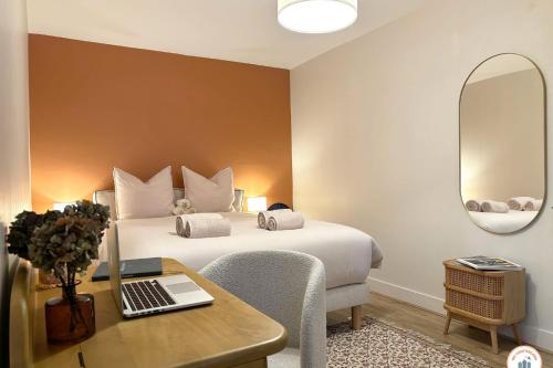 une chambre avec un lit et un bureau avec un ordinateur portable dans l'établissement Les Bains de Trouville - Standing - Hypercentre, à Trouville-sur-Mer