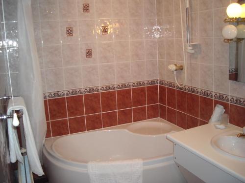 a bathroom with a tub and a sink at Townstal Farmhouse in Dartmouth