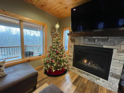a christmas tree in a living room with a fireplace at Big and Boulder in McHenry