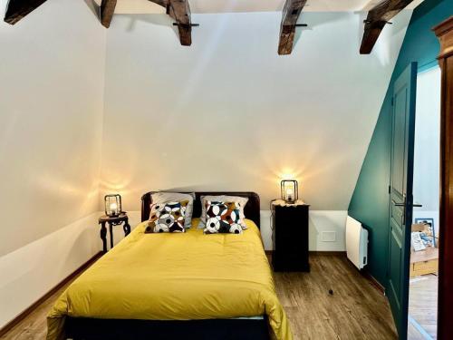 a bedroom with a yellow bed with two pillows at Gîte de France Chez le bassot 3 épis - Gîte de France 6 personnes MAE-1461 in Monceaux-sur-Dordogne