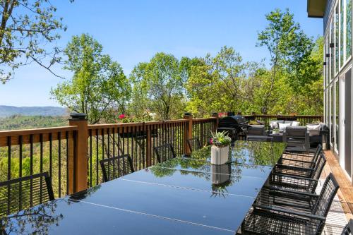 a patio with a table and chairs on a fence at LUXE, Breathtaking Mountain Views, Hot Tub, Fire Pit, Fire Pit Table, Pool Table, 2 Living rooms, Universal EV Station in Hendersonville