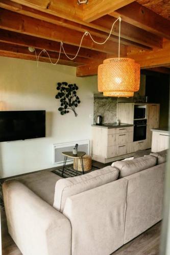 un salon avec un canapé blanc et une table dans l'établissement Gîte de France Armand 4 épis - Gîte de France 4 personnes MAE-1511, à Palazinges