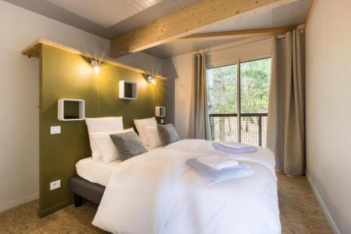 une chambre avec un grand lit blanc et une fenêtre dans l'établissement Gîte de France Armand 4 épis - Gîte de France 4 personnes MAE-1511, à Palazinges