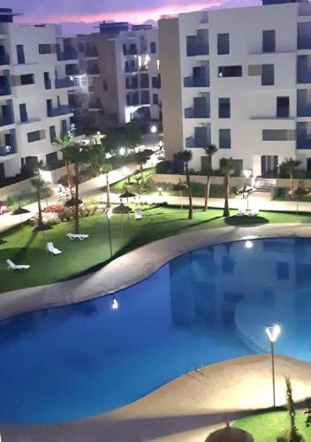 a large swimming pool in front of a building at Appartement complexe Costa Mar avec piscine privée très sécurisé 3min de la plage Luxe et détente in Martil