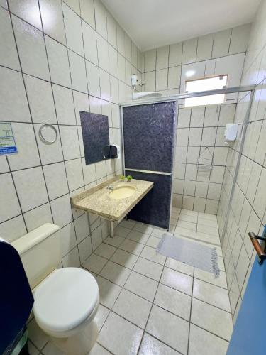 a bathroom with a toilet and a sink and a shower at Pousada Cambará Suítes in Bonito