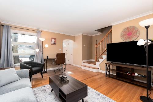 a living room with a couch and a flat screen tv at Charming Oak Park Retreat in Oak Park