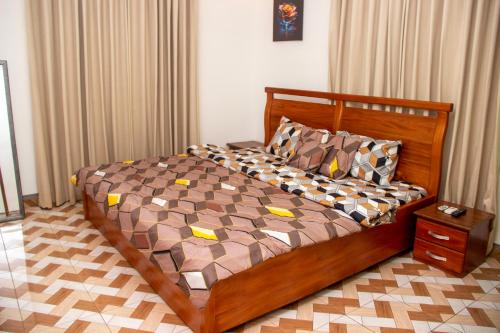 a bedroom with a large wooden bed in a room at Kenest Villa - 3 Master-Bedrooms in Oyarifa