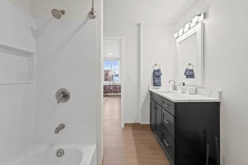 a white bathroom with a sink and a shower at Spacious Apartment with King Beds - J and K on Main in Spokane