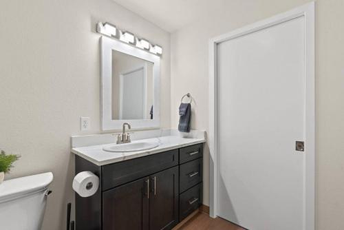 ein Badezimmer mit Waschbecken, Spiegel und Toilette in der Unterkunft Roav Stays - J and K Luxury Apartment 304 in Spokane