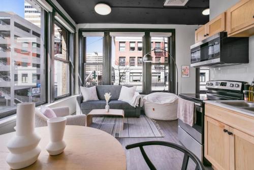 a kitchen and living room with a couch and a table at Urban SoHo Suite in the Heart of Downtown in Spokane