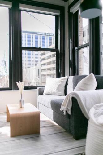 a living room with a couch and a large window at Urban SoHo Suite in the Heart of Downtown in Spokane