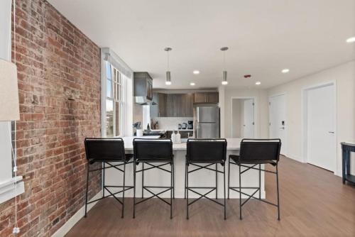 a kitchen with a brick wall and bar stools at Luxury w King Beds, Pool Table, Central Downtown! in Spokane