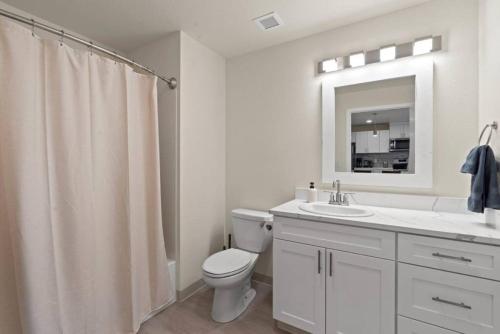 Un baño blanco con inodoro y lavabo. en Brunch & Coffee Near! Spacious Downtown Stay 302, en Spokane