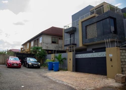 two cars parked in front of a house at Kenest Villa - 3 Master-Bedrooms in Oyarifa