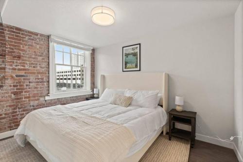 a bedroom with a large bed with a brick wall at Spacious, King Bed, w Pool Table & Brunch Below! 303 in Spokane