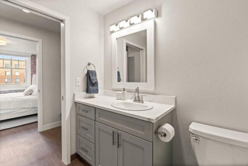 a bathroom with a sink and a toilet and a mirror at Spacious, King Bed, w Pool Table & Brunch Below! 303 in Spokane