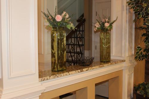 three vases filled with flowers sitting on a mantel at Paradise Suite - Pueblo Bonito in McDonough