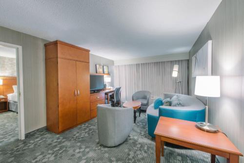 a hotel room with a couch and a living room at Courtyard by Marriott Nashua in Nashua