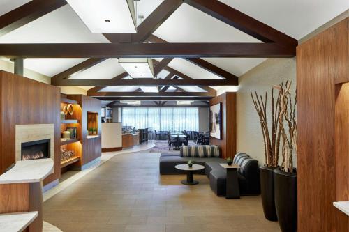 a lobby with a waiting area with a fireplace at Courtyard Rochester East / Penfield in Rochester
