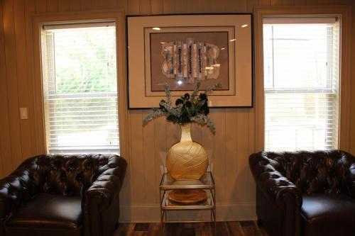 a living room with two leather chairs and a vase at Paradise Suite - Pueblo Bonito in McDonough