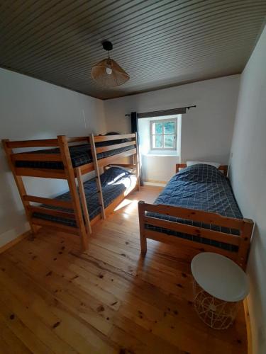 une chambre avec deux lits superposés et une table dans l'établissement Maison de campagne, à Montusclat