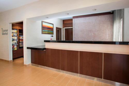 a lobby with a counter and a large mirror at Wingate by Wyndham Oshkosh in Oshkosh