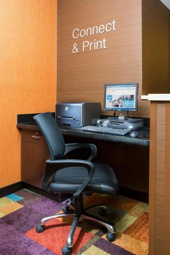 an office with a desk with a computer and a chair at Wingate by Wyndham Oshkosh in Oshkosh
