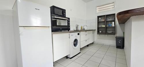 a kitchen with a refrigerator and a washer and dryer at Residence St Antoine in Cayenne
