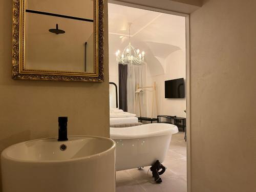 a bathroom with a bath tub and a mirror at Residence London 1891 - design apartments in Karlovy Vary