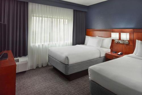 a hotel room with two beds and a window at Courtyard by Marriott Tallahassee Downtown/Capital in Tallahassee