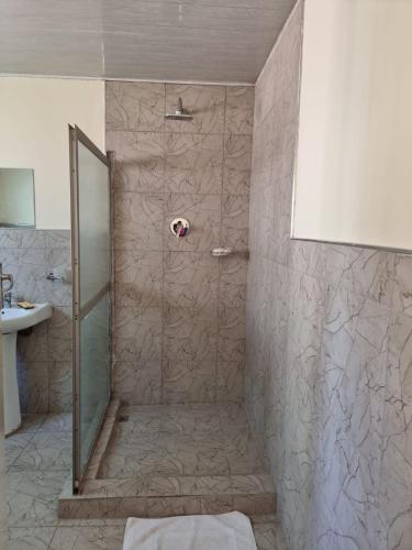 a shower with a glass door in a bathroom at Hideout in Highlands in Harare