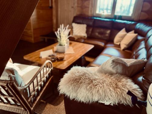 a living room with a leather couch and a table at Piparmētras in Mērsrags