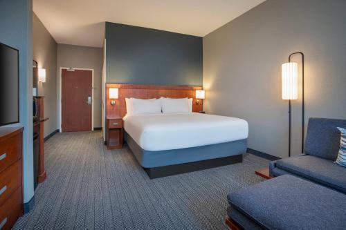 a hotel room with a bed and a couch at Courtyard Fort Lauderdale SW Miramar in Miramar