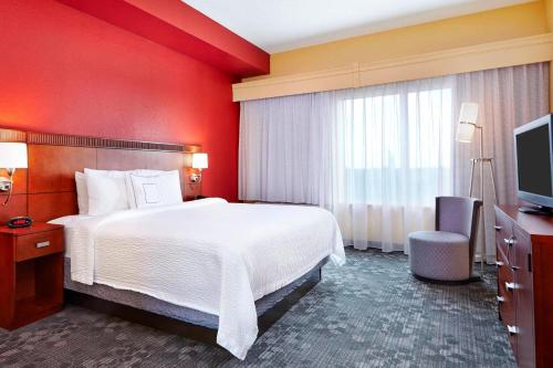a hotel room with a bed and a television at Courtyard Fort Lauderdale SW Miramar in Miramar