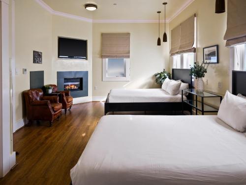 a hotel room with two beds and a fireplace at Inn at Sonoma, A Four Sisters Inn in Sonoma