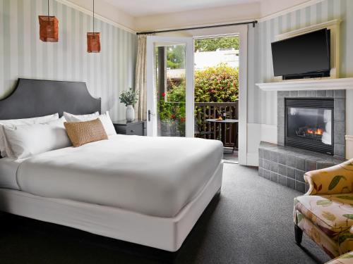 a bedroom with a white bed and a fireplace at Inn at Sonoma, A Four Sisters Inn in Sonoma