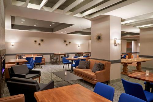 a restaurant with tables and blue chairs and tablesktop at Courtyard by Marriott Toronto Downtown in Toronto