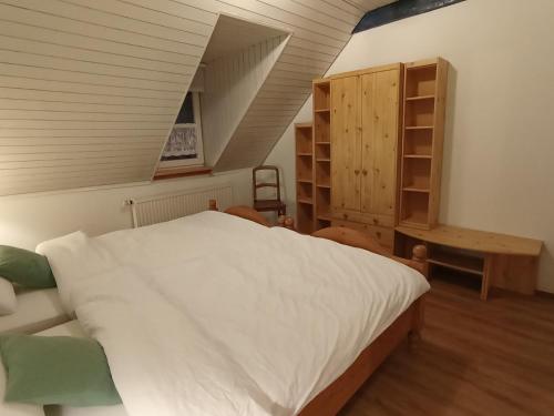 a bedroom with a white bed and a staircase at Dachgeschoss - Maria von Berg - Wohnen auf Zeit in Rottweil
