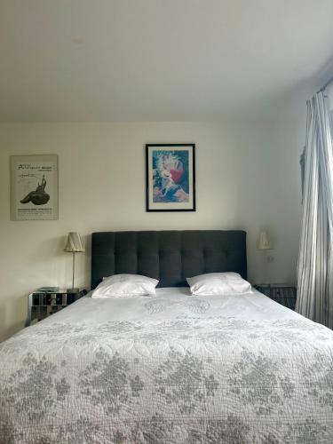 une chambre avec un grand lit avec une tête de lit bleue dans l'établissement La Maison D'Edouard, à Montastruc-de-Salies