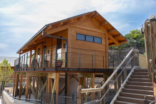 una casa en una estructura de madera con escaleras en San Antonio Zoo - Spekboom Giraffe Lodge, en San Antonio